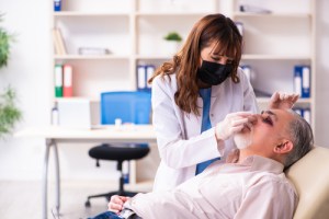 Man with black eyes and facial trauma and doctor checking